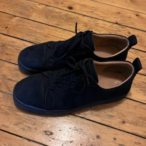 Blåa loubs - Snygga blåa sneakers med röd sula och snörning. Perfekta för en stilren look. Priset är diskuterbart