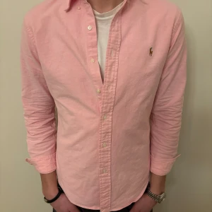 Rosa skjorta från Ralph Lauren - Otroligt fet rosa polo skjorta som är en av våra personliga favoriter🤩🔥👔🤙otroligt bra skick på denna skjortan( inga skavanker) nypris ca 1499kr💰 Storlek: M (lite mindre i midjan)