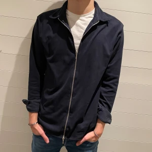 Mörkblå overshirt - Väldigt snygg mörkblå overshirt/kofta från Ciszere i storlek M. Jackan har en dragkedja framtill och är gjord i skönt tyg. Den är perfekt för varmare vinter dagar eller till vår! Denna overshirt tillverkas ej längre och är sällsynt i såhär bra skick. Modellen är 180cm lång och bär storlek M. Vid funderingar eller frågor är det bara att höra av sig🙌 pris kan alltid diskuteras!