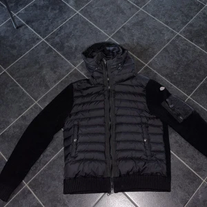 Svart moncler cardigan  - Tjena, vill sälja min moncler cardigan på grund av att den aldrig används. Den är nästan som helt ny, inga skador eller så. Storleken på den är L men kan också passa M. Perfekt för kyligare dagar. Den är äkta såklart men har bara kvitto på bild på grund av att jag tappa bort den vid flyttning, därav priset också. Hör av er vid frågor tack!!!😁