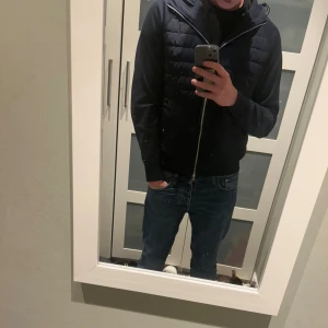  Tommy Hilfiger cardigan - Säljer en stilren cardigan från Tommy Hilfiger. Jackan har en dragkedja framtill och en huva för extra skydd. Perfekt för kyligare dagar med sin snygga design och bekväma passform. Nypris ligger runt 2500kr bara att höra av sig vid eventuella frågor!