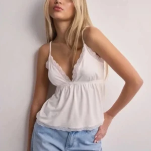 Vit linne med spets - Säljer denna trendiga topp från Nelly som är så fin nu när det snart är vår och sommar. Jättebra skick, bara använd några gånger men passar tyvärr inte. Fråga för fler bilder och använd gärna köp nu💕🐚