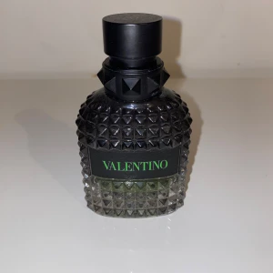 Valentino Uomo Born in Roma Green Stravaganza - Säljer en flaska Valentino Uomo Born in Roma Green Stravaganza. Flaskan har en lyxig design med nitar och en elegant svart och grön etikett. Perfekt för den som vill ha en unik och stilren doft.