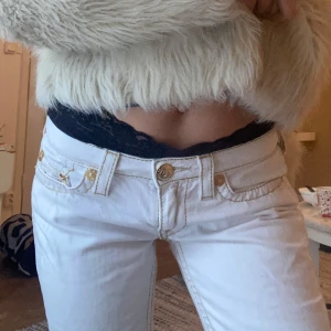 Äkta true religion jeans i vit & guld  - Säljer mina unika vita true religions med guldsömmar i toppenskick. Straight leg fit o lite vidare längst ner, se bild. Kan mötas i Sthlm eller frakta! Midjemått: 68 cm, längd 2m🥰