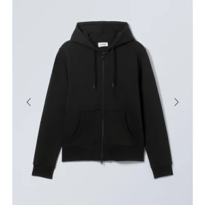 Svart zip hoodie  - Snygg och bekväm svart zip hoodie från weekday  med dragkedja och justerbar huva. Perfekt för en avslappnad stil. Den har en klassisk passform med fickor framtill.