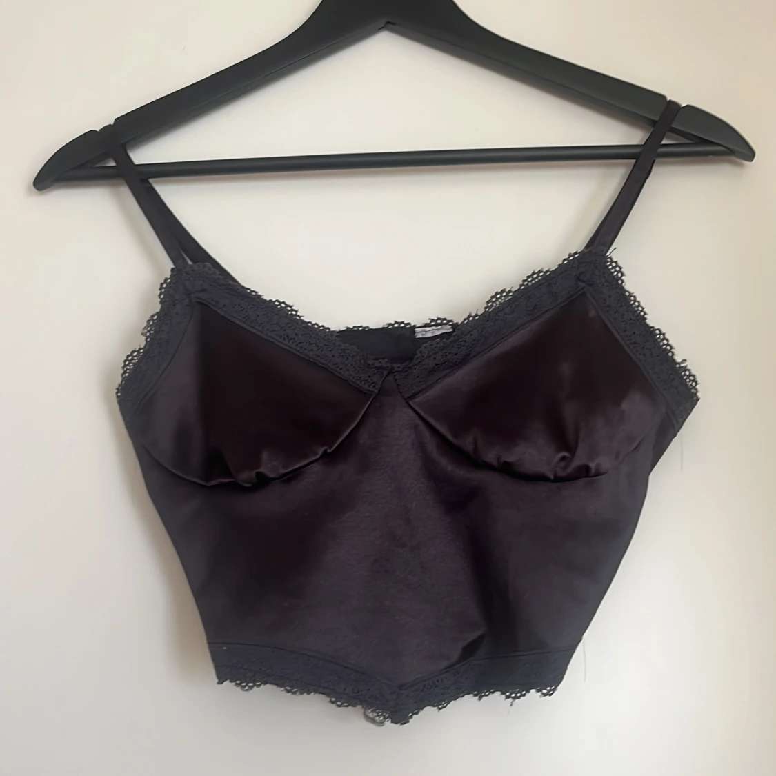 Svart satinlinnetopp med spetsdetaljer