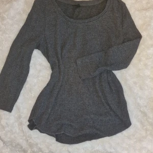 Grå ribbad tröja från Gina Tricot - Säljer en stilren grå ribbad tröja från Gina Tricot. Tröjan har en rund halsringning och långa ärmar, perfekt för kyligare dagar. Passar bra till både jeans och kjol. Ett måste i garderoben för en enkel och snygg look.