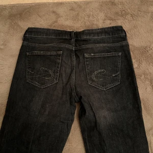 Vintage low waist jeans  - Säljer dessa jätte coola vintage low waist jeansen i en bootcut modell, de har detaljer på fickorna och är svarta gråa. Jag är 167 och de sitter bra i längden på mig. Storlek W29 L32. Skriv för fler bilder🫶🏼