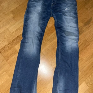 Blå jeans från Diesel - Snygga blå jeans från Diesel med en klassisk straight fit. De har en lätt slitning för en cool look och är tillverkade i denim. Perfekta för en avslappnad stil. Använda fåtal gånger. 9/10 skick