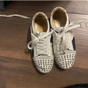 Vita sneakers med nitar från Christian Louboutin - Snygga vita sneakers från Christian Louboutin, helt okej skick men ganska slitna därav priset 💕kan skicka fler bilder på skicket