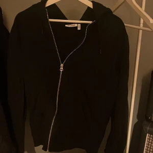 Svart hoodie från Weekday - Säljer en stilren svart hoodie från Weekday i storlek S. Storleken är dock lite oversized och passar därmed också M.
