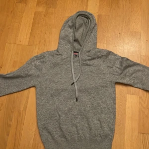 Grå kashmir hoodie från William De Faye - Säljer en stilren grå kashmir hoodie från William de Faye. Perfekt för en avslappnad look. Den är i storleken small och nypris på ca 1500. Välanvänd, liten slitning i halsen och lite nopprig därav det låga priset. Priset är inte spikat och är villig att förhandla