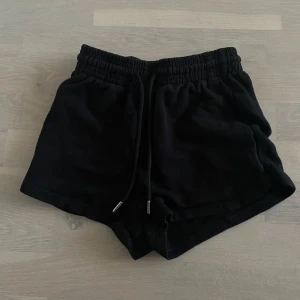 Svarta shorts med snörning - Snygga svarta shorts med elastisk midja och snörning. Perfekta för en avslappnad stil. De är korta och har en bekväm passform.