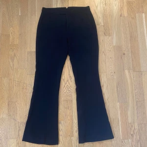 Lågmidjade kostymbyxor från Zara - Superfina svarta kostymbyxor från Zara! De har en innerbenslängd på ca 80 cm och ett midjemått på ca 80 cm. De har ett hål i ena framfickan och knappen har tyvärr åkt av, dock går det fortfarande utmärkt att knäppa dem med hjälp av spännet.💕💕