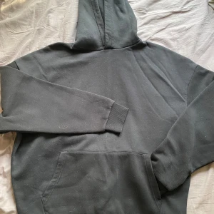 Svart hoodie - Svart hoodie med framficka, generöst använd med bra passform. 