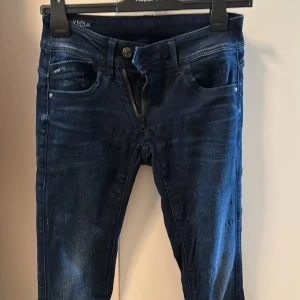 G-star jeans dam - Mörkblåa jeans från G-star. Modellen är slim. Storlek W27 L34. Fin modell med dragkedja som syns och är lite på snedden. 