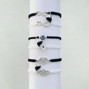 Svart och vitt armband set med silverdetaljer - Säljer ett set med snygga armband i svart och vitt. Armbanden har coola silverdetaljer som infinity-symboler och hjärtan. Perfekt för att mixa och matcha till olika outfits. De är justerbara och passar de flesta handleder. Perfekt accessoar för både vardag och fest!