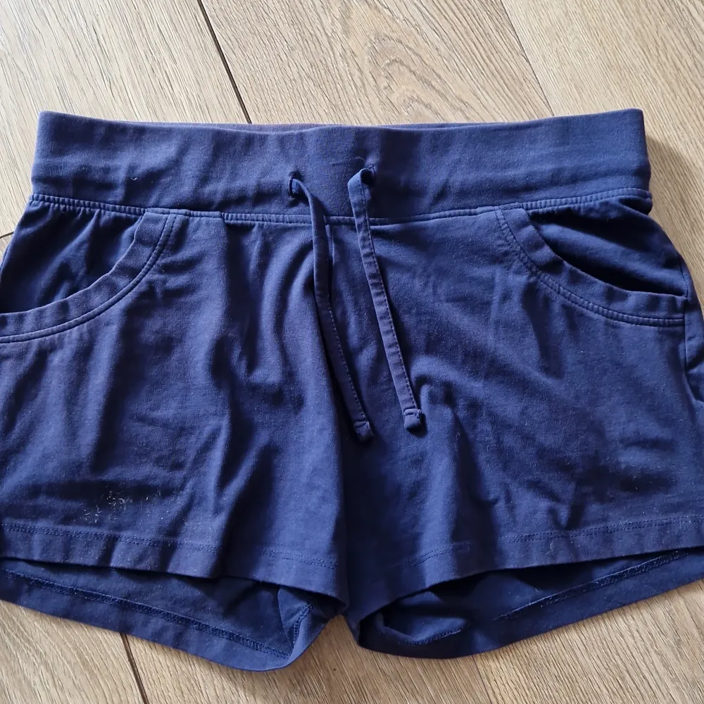 Säljer ett par mörkblå shorts från Esmara. De är superbekväma med en elastisk midja och dragsko för perfekt passform. Shortsen har två praktiska fickor på sidorna och är gjorda i mjukt bomullsmaterial. Perfekta för en avslappnad dag eller sommarens äventyr! 🌞. Shorts.