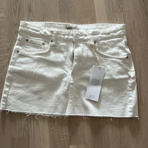 Vit jeanskjol från Perfect Jeans - Säljer en snygg vit jeanskjol från Perfect Jeans i storlek S. Kjolen har en rå kant nertill och klassiska femfickor. Den har en dragkedja och knapp framtill för enkel på- och avtagning. Perfekt för sommaren och kan matchas med nästan vad som helst! 🌞