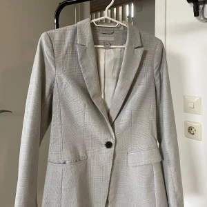 En väldigt fin grå kavaj - En fin kavaj som man kan ha vi flera tillfällen. Använt ungefär 2 gånger.