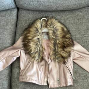 Säljer en superfin rosa skinnjacka från Mywear Young. Den har en fluffig fuskpäls runt kragen som ger en lyxig känsla. Jackan har dragkedjor framtill och på fickorna, vilket ger den en cool look. Perfekt för höst och vår!