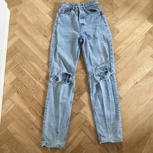 Blåa slitna jeans - Säljer ett par slitna jeans från h&m i storlek 32. Slitna längst ner på benen annars fina. 