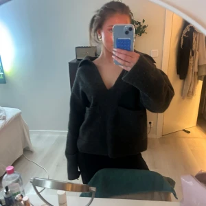 Mörkgrå tröja med v-ringning - Säljer en mysig mörkgrå tröja med v-ringning och långa ärmar. Perfekt för kyligare dagar och ger en avslappnad look. Tröjan har en lös passform och är enkel att matcha med olika outfits.🌟❣️💫😍