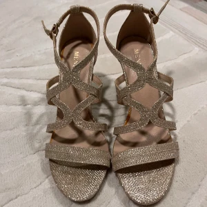 Skor - Snygga glittriga, guldiga klackar. Nya, använda 1-2 ggr