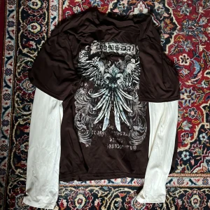 Y2K Brun/vit långärmad t-shirt med tryck - Y2K tisha med tryck på framsidan, själva tröjan e brun och sen har den inbyggda långa ärmar som är lite biege-vita. I toppen skick!✨