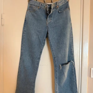 Blå jeans med slitning - Snygga blå jeans med en cool slitning på ena benet. från bikbok 