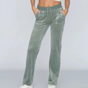 Gröna Juicy Couture mjukisbyxor - Snygga gröna mjukisbyxor i sammet med snörning i midjan. Byxorna har praktiska fickor både fram och bak med knappdetaljer. Perfekta för en avslappnad stil. Från juicy couture, nästan oanvända i fint skick❤️🥰