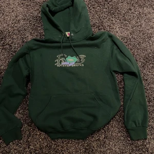 Mörkgrön hoodie från märket ”Frog” - Säljer en mörkgrön hoodie från märket ”Frog”. Tröjan är väldigt skön och har en snygg grön färg.