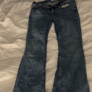 Blå jeans från Perfect Jeans - Säljer ett par klassiska blå jeans från Perfect Jeans. De har en bootcut-stil och är tillverkade i denim med två knappar och dragkedja framtill. Har även sytt om dom så dom skulle sitta lite tajtare på låret.Perfekta för en avslappnad look.