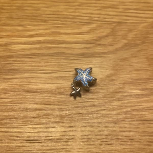 Pandora berlock  - En liten snäck berlock i ljusblå färg