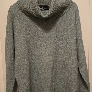 Grå och blå polotröja från H&M - Säljer två mysiga polotröjor från H&M i grått och blått. Perfekta för kyliga dagar med sin mjuka och varma känsla. Tröjorna har långa ärmar och en bred polokrage som ger extra värme och stil. Passar perfekt till jeans eller kjol för en avslappnad look.