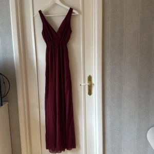 Balklänning vinröd  - Elegant vinröd långklänning med djup v-ringning och breda axelband. Perfekt till balen❣️❣️❣️