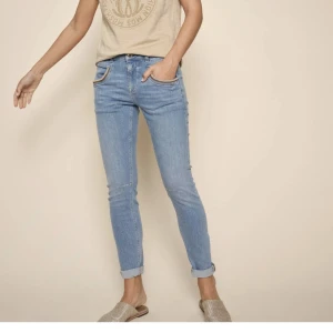 Blå skinny jeans - Säljer ett par snygga blå jeans från Mos mosh med skinny passform. Modellen heter Naomi scala jeans, 30" cropped.  Nya med prislapp,  bara provade  Uppskattar att de passar bäst om du har stl 40-42. Nypris 1499-1795kr Midja ca 42cm 