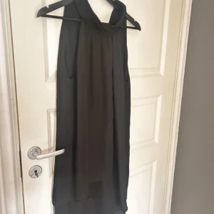 Svart ärmlös klänning från Zara Basic - Snygg svart ärmlös klänning från Zara Basic. Den har en elegant design med en hög krage och en lätt A-linjeform. Perfekt för en stilren look. 🖤storlek l men passar mig i s 