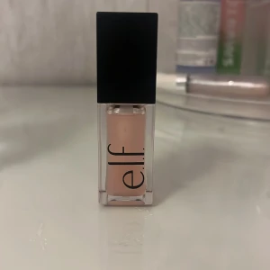 Läppglans från e.l.f. - Snyggt läppglans från e.l.f. i en ljusrosa nyans. Kommer i en stilren, fyrkantig förpackning med svart lock. Perfekt för att ge läpparna en glansig finish.