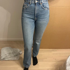 Blå jeans med hög midja - Snygga blå jeans med hög midja och klassisk femficksdesign. De har en straight passform som ger en tidlös look. Perfekta för en avslappnad stil.