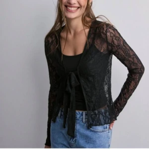 Spets blus - Svart spets blus med knytning i fram från NELLY strl xxs, men passar även xs. Endast använd ett par gånger