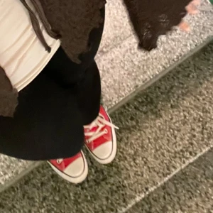 Röda Converse All Star sneakers - Säljer ett par klassiska röda Converse All Star sneakers i välanvänt skick. De har den ikoniska vita sulan och snörning. Perfekta för en avslappnad stil och passar till nästan allt. Sköna och tidlösa, dessa sneakers är ett måste i garderoben!