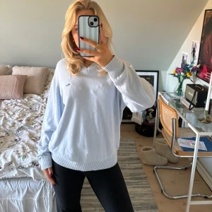 Ljusblå tröja från Lacoste - Säljer en superfin ljusblå tröja från Lacoste. Den har en v-ringning och är gjord i ett mjukt material som känns skönt mot huden. Perfekt för både vardag och lite finare tillfällen. Tröjan har långa ärmar och den klassiska krokodilloggan på bröstet. Passar perfekt till höst och vår🩵 I begagnat skick. 