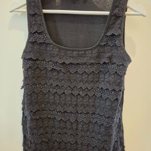 Topp/Linne Lindex - Svart Topp/Linne från Lindex. Mönstrad på framsidan, men clean på ryggen. Storlek S. Mjuk och skön material. Använd några gånger. 100% polyester. 