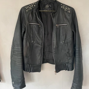 Vintage Skinnjacka i äkta läder  - Vintage skinnjacka från zara. Inköpt cirka 2010. Äkta läder så jackan har hållit i många år. Snyggt sliten med nitar. 