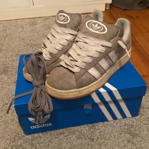 Addidas campus 00 grå - Ett par Rikgit snygga Addidas campus i storlek 44 2/3. Kvitto finns, Skick 7/10 det är bara två små hål i skon som ni ser på bild 5. Skriv vid minsta fråga eller fundering🔥