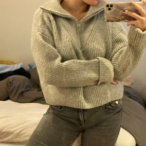 Grå stickad tröja med dragkedja - Säljer en supermysig grå stickad tröja med half-zip. Perfekt för kyliga dagar när du vill vara både varm och stilren. Passar till både jeans och kjol!