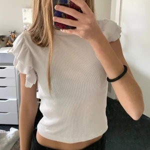 Vit ribbad topp - Strl 134-140, vit topp/t-shirt, lite lätt ribbad, använt 1-2 gånger och inga fläckar, kan användas till vardags men också till finkläder