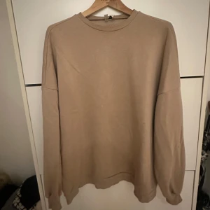 Beige sweatshirt - Säljer en stilren och bekväm beige sweatshirt. Den har en lite oversize passform med långa ärmar och rund hals. Perfekt för en avslappnad look under höst och vår.