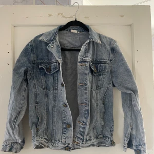 Jeansjacka från Jeantex - Säljer en snygg jeansjacka från Jeantex i storlek XS. Den är i en klassisk ljusblå denimfärg och har en cool vintage-look. Jackan har långa ärmar och knappar framtill. Perfekt för vår och sommar!